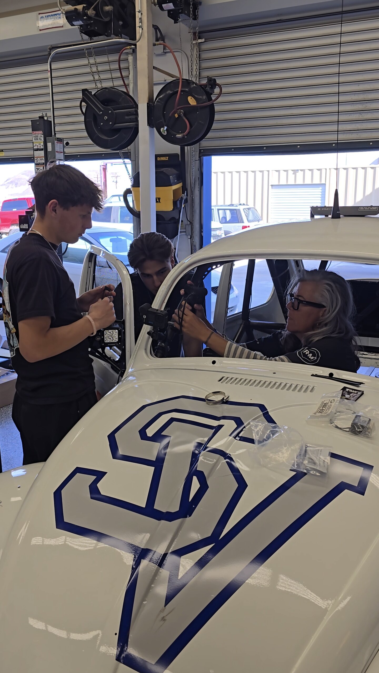 Emme Hall working with Silver Valley High School students to install race-media equipment in car 1125